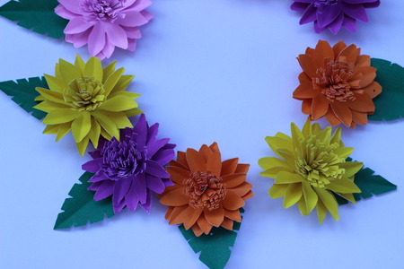 Many colorful paper flowers on a background with a smooth surfaceの写真素材