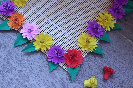 Many colorful paper flowers on a background with a smooth surfaceの写真素材