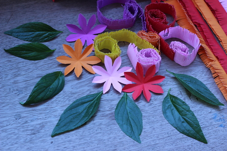 Many colorful paper flowers on a background with a smooth surfaceの写真素材