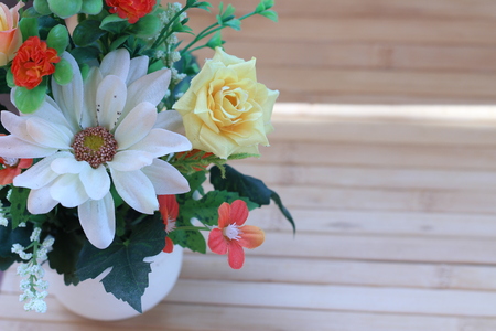 Beautiful flowers in a vase on a wooden brown backgroundの写真素材