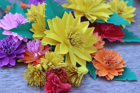 Many colorful paper flowers on a background with a smooth surfaceの写真素材
