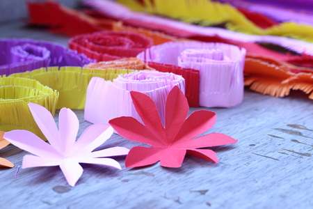 Many colorful paper flowers on a background with a smooth surfaceの写真素材