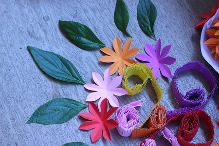 Many colorful paper flowers on a background with a smooth surfaceの写真素材