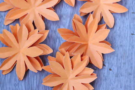 Many colorful paper flowers on a background with a smooth surfaceの写真素材