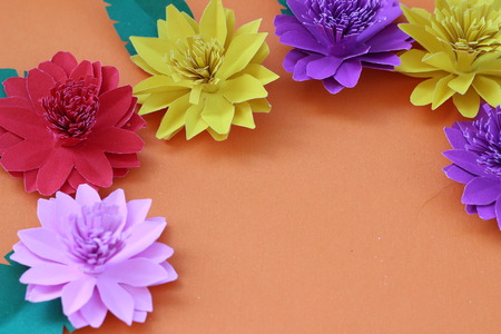 Many colorful paper flowers on a background with a smooth surfaceの写真素材