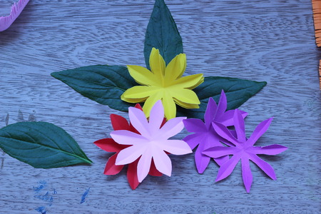 Many colorful paper flowers on a background with a smooth surfaceの写真素材