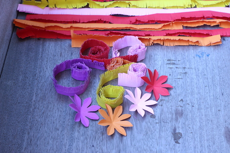 Many colorful paper flowers on a background with a smooth surfaceの写真素材