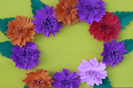 Many colorful paper flowers on a background with a smooth surfaceの写真素材