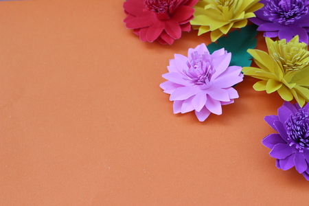 Many colorful paper flowers on a background with a smooth surfaceの写真素材