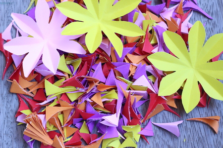 Many colorful paper flowers on a background with a smooth surfaceの写真素材