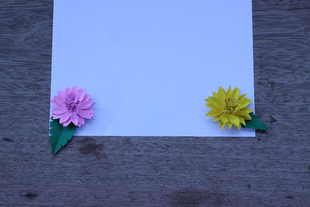 Many colorful paper flowers on a background with a smooth surfaceの写真素材