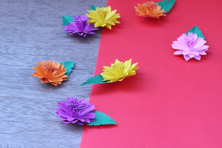 Many colorful paper flowers on a background with a smooth surfaceの写真素材