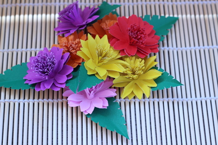 Many colorful paper flowers on a background with a smooth surfaceの写真素材