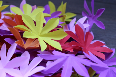 Many colorful paper flowers on a background with a smooth surfaceの写真素材