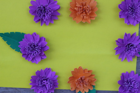 Many colorful paper flowers on a background with a smooth surfaceの写真素材
