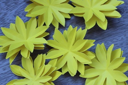 Many colorful paper flowers on a background with a smooth surfaceの写真素材