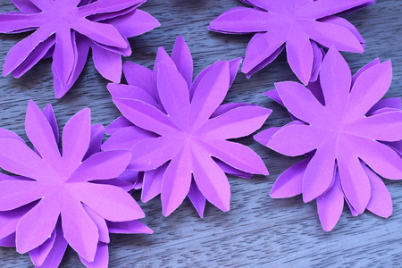 Many colorful paper flowers on a background with a smooth surfaceの写真素材