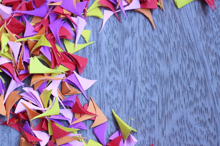 Beautiful colored paper cut into small pieces and piled on the old wooden gray backgroundの写真素材