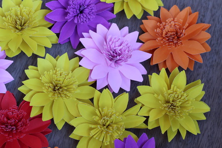 Many colorful paper flowers on a background with a smooth surfaceの写真素材