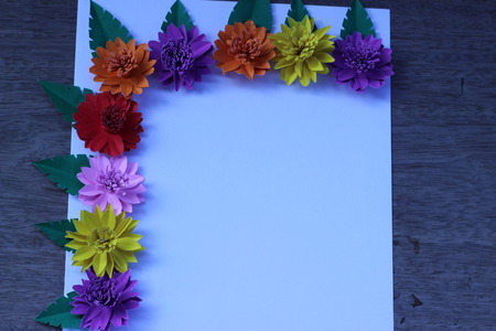 Many colorful paper flowers on a background with a smooth surfaceの写真素材