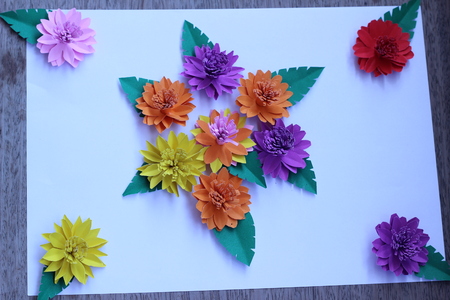 Many colorful paper flowers on a background with a smooth surfaceの写真素材