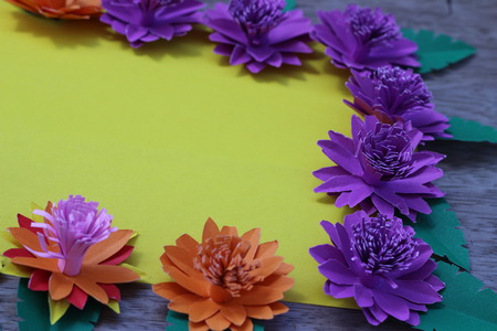 Many colorful paper flowers on a background with a smooth surfaceの写真素材