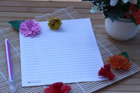 Writing paper and pen placed on a wooden brown backgroundの写真素材