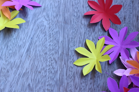 Many colorful paper flowers on a background with a smooth surfaceの写真素材