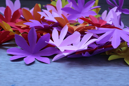 Many colorful paper flowers on a background with a smooth surfaceの写真素材