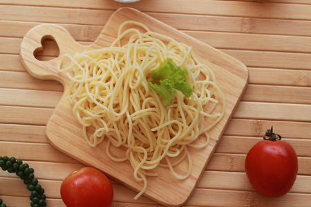 Spaghetti in a white plate and sliced sugar with red ketchupの写真素材