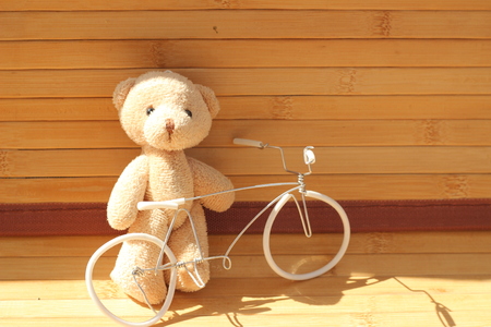 Cute brown bear doll on brown backgroundの写真素材