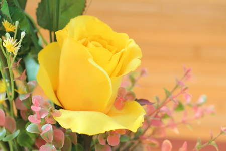 Yellow roses are arranged in bouquets on a brown backgroundの写真素材
