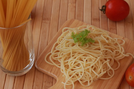 Spaghetti in a white plate and sliced sugar with red ketchupの写真素材
