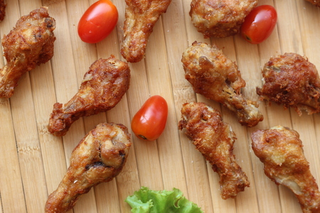 Deep fried chicken is served in a flat white dish on a brown backgroundの写真素材