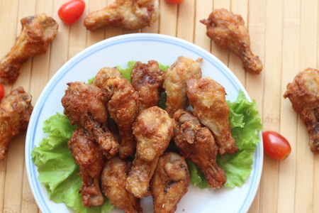 Deep fried chicken is served in a flat white dish on a brown backgroundの写真素材