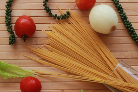Spaghetti in a white plate and sliced sugar with red ketchupの写真素材