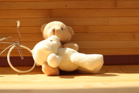 Cute brown bear doll on brown backgroundの写真素材