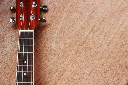 Brown Ukulele Lay on Old Brown Wood Tableの写真素材