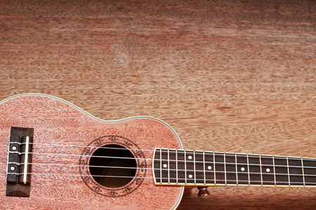 Brown Ukulele Lay on Old Brown Wood Table
