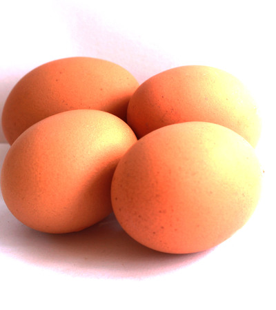 Boiled eggs that are not peeled and peeled in a brown container on a white background.の写真素材
