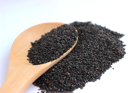Black sesame in a brown cup on a white backgroundの写真素材