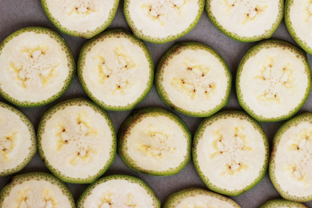 Raw bananas are cut together on a white backgroundの写真素材