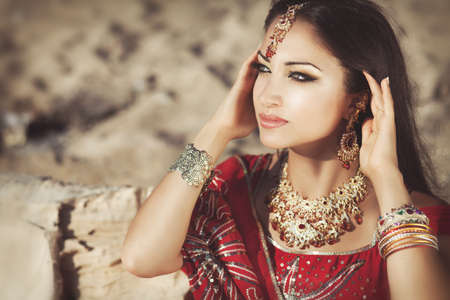 Beautiful young indian woman in traditional clothing with bridal makeup and jewelry  gorgeous brunette bride traditionally dressed Outdoors in India  Girl bollywood dancer in Sari  Arabian bellydancerの写真素材