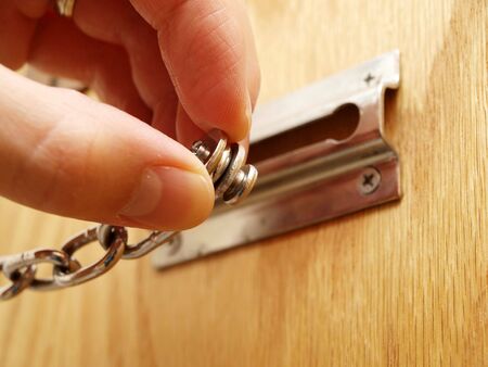 Security chain with a hand holding the lockの写真素材
