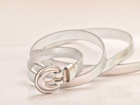 A silver belt, in a twirl on white backgroundの写真素材