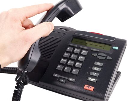 Someone hanging up, putting the handset down on a office phone, isolated on white backgroundの写真素材