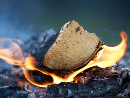 A log burning, flames and smoke on a bonfireの写真素材