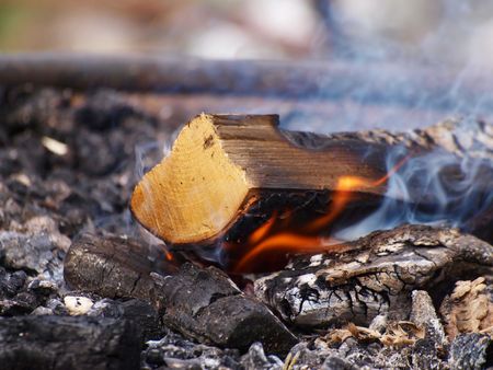 A log burning, flames and smoke on a bonfireの写真素材