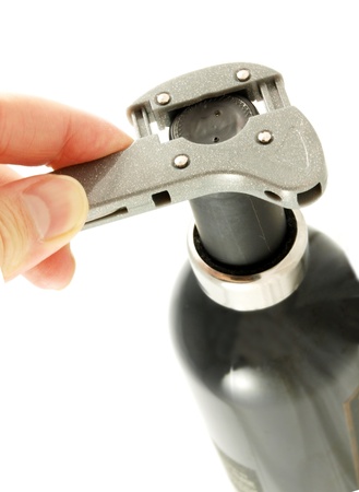 Someone opening a wine bottle, removing the plastic cover on topの写真素材