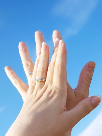 Married couple holding hands towards fresh blue skyの写真素材